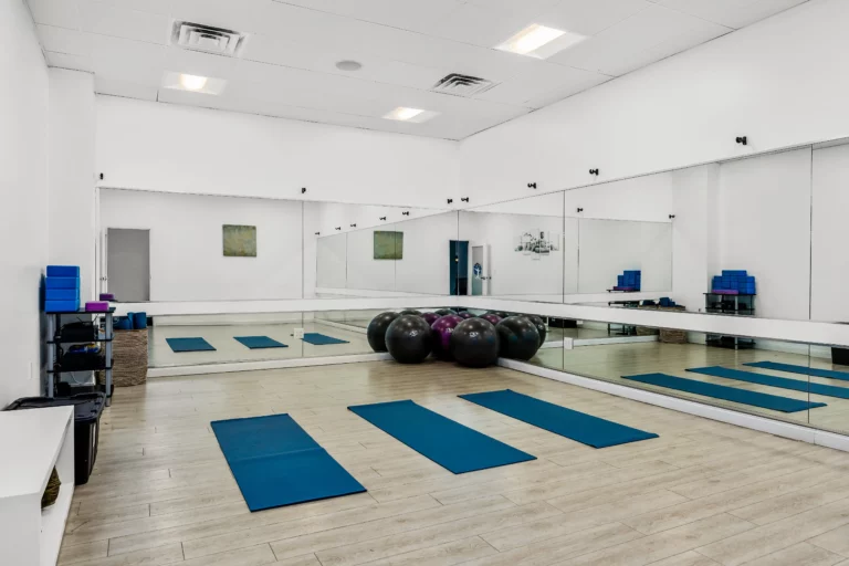 Gym with mats, exercise equipment, and mirrors at Legacy Healing Center’s Cherry Hill drug and alcohol rehab center