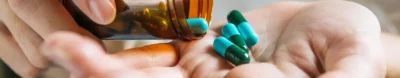 woman-s-hand-pours-medicine-pills-out-bottle